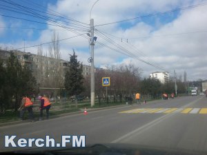 Новости » Общество: В Керчи на Камыш-Бурунском шоссе рабочие красят заборы