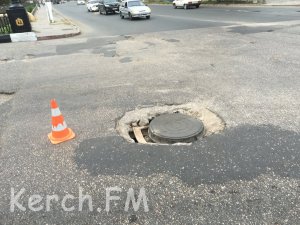 Новости » Общество: В Керчи на проезжей части провалился асфальт возле люка