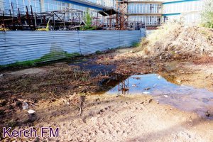 Новости » Общество: В Керчи из-под забора долгостроя пресная вода течет в море