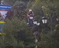В Симферополе у горсовета мужчина залез на столб и начал раздеваться (видео)