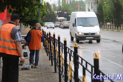 Новости » Общество: В Керчи в дождь коммунальщики красили заборы