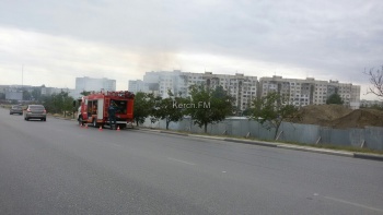 В Керчи горит трава рядом со стройкой нового дома