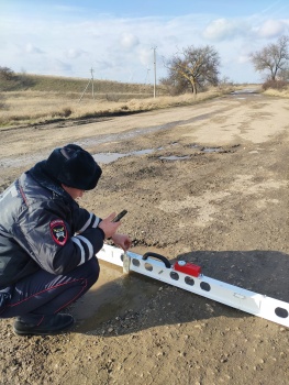 Сотрудники ГИБДД с линейкой измеряют ямы на дорогах в Ленинском районе