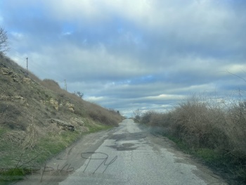 Новости » Общество: Дыры на дороге к Еникале в Керчи засыпали асфальтовой крошкой